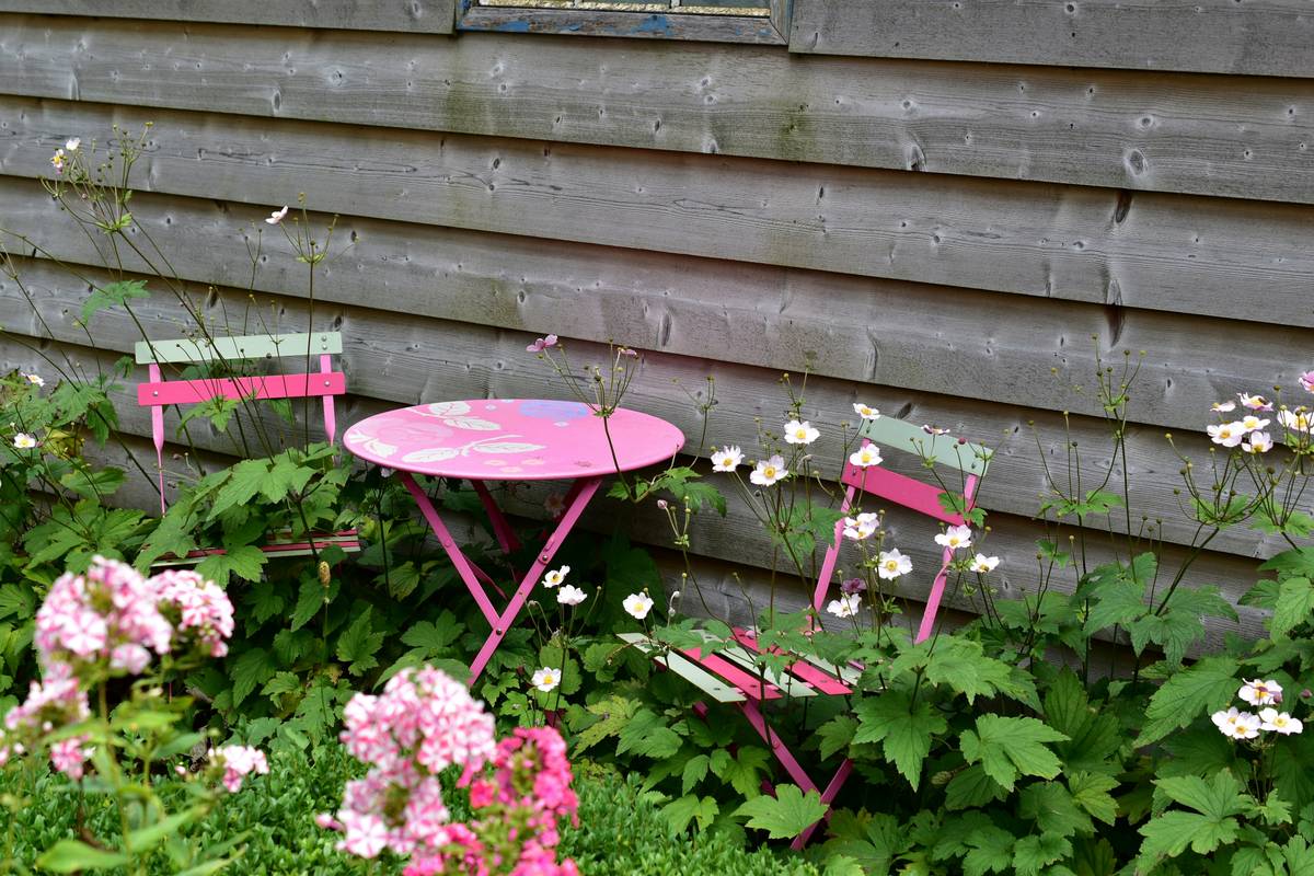 handcrafted farmhouse style garden furniture set on a rustic patio with potted herbs and string lights